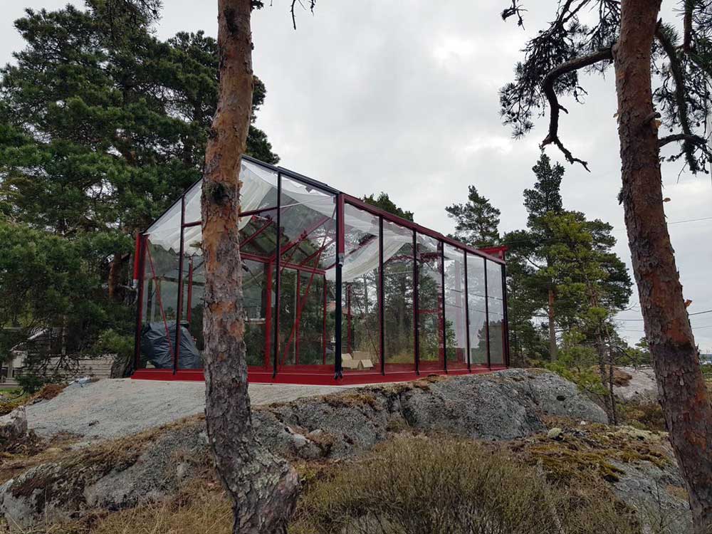 Nybyggnation av stort växthus i röd metall och glas.
